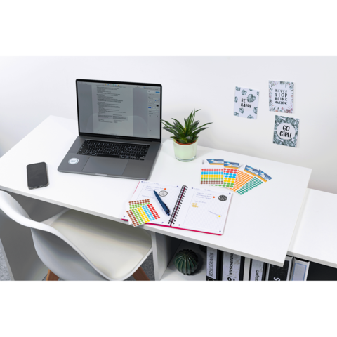 Ein moderner Schreibtisch mit einem Laptop, Notizbuch, bunten Notizen, einer Pflanze und einem Smartphone. An der Wand hängen inspirierende Zitate.