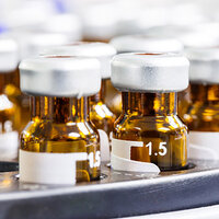 Étiquettes en autocollant rond sur des flacons de médicaments bruns.