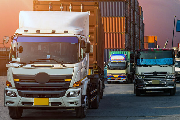 The translation of "LKWs mit Containern" into French is "camions avec des conteneurs.