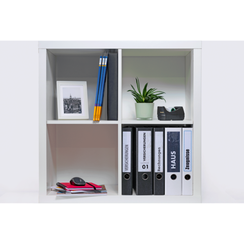 Ein Regal mit Ordnern, einem Pflanzengefäß, Bleistiften, einer Fotografie und Büromaterialien.