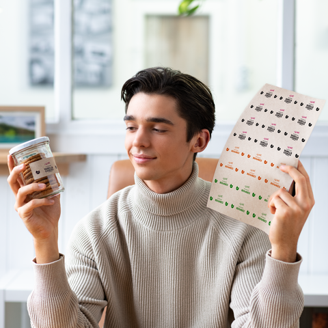 Ein junger Mann in einem Blazer hält einen Kaffeebecher und eine Mappe mit Dokumenten in der Hand, während er nachdenklich schaut.