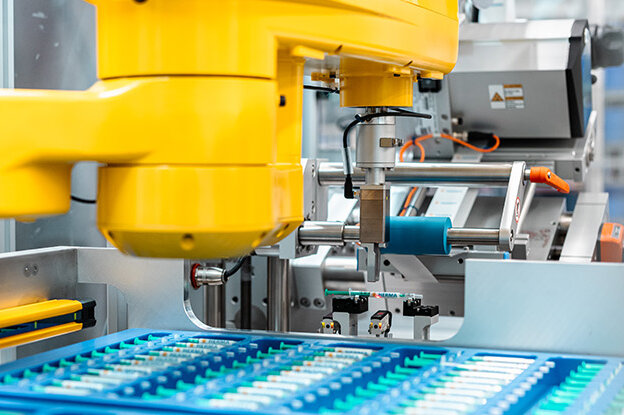 Des robots industriels avec deux modèles différents, l'un sur une table et l'autre sur une unité de montage, entourés de graphiques techniques.