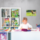 Ein Mädchen sitzt an einem Schreibtisch, malt und schreibt in ein Heft. Im Hintergrund sind Regale mit Spielzeug und Bastelmaterialien.