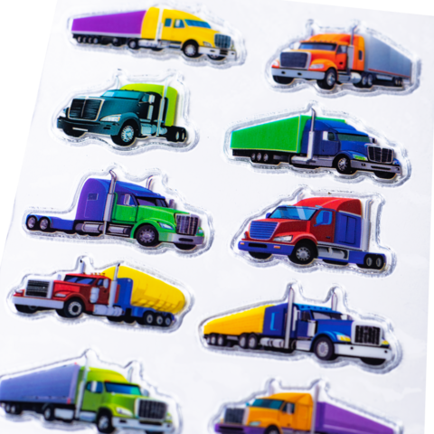 Autocollants colorés de camions dans différentes couleurs et designs, disposés en deux rangées.