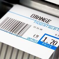 Étiquette thermique imprimée pour oranges, sur une balance.