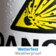 Gelbes Warnsymbol mit Sonnenstrahlen und Wassertropfen, darunter der Text "Wetterfest" in Deutsch und "Weatherproof" in Englisch.