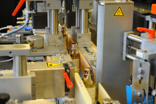 Machines automatisées pour le traitement des bouteilles, avec différents composants mécaniques et des étiquettes de sécurité.