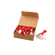 Eine geöffnete Kartonbox mit roten und weißen Fäden sowie Etiketten, die zum Beschriften oder Dekorieren verwendet werden können.