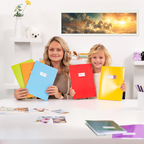 Une femme et un enfant sont assis à une table, tenant des classeurs colorés. Sur la table, il y a des photos, et en arrière-plan, on peut voir une image de chevaux.