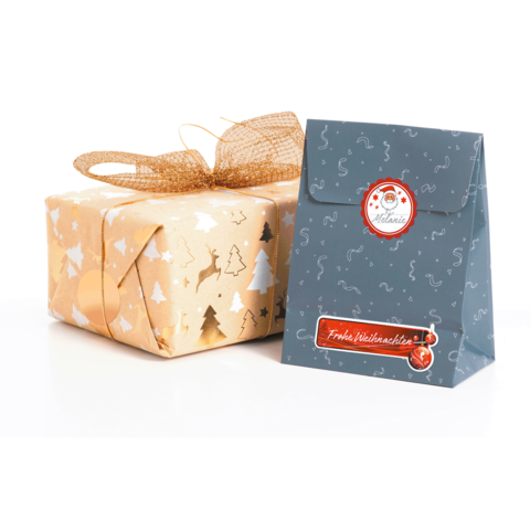 Geschenkverpackung in Gold mit Weihnachtsmotiven und eine blaue Tüte mit dem Aufdruck „Frohe Weihnachten“.