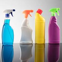 Une série de bouteilles de produits de nettoyage de différentes couleurs : bleu, orange, jaune et violet, sur un fond réfléchissant.