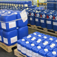 Étiquettes GHS et étiquettes chimiques sur des bidons en plastique bleus, sur des palettes.