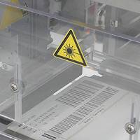 Étiquettes activables par laser avec code-barres dans le processus de production, gros plan de l'unité d'impression laser CO2.