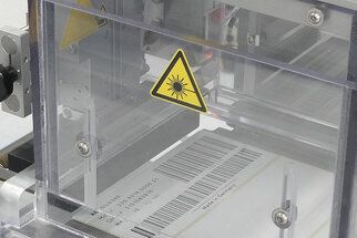 Étiquettes activables au laser : avec code-barres dans le processus de production, gros plan de l'unité d'impression laser CO2.