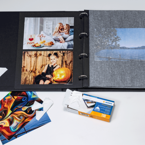 Un album photo contenant plusieurs images, y compris des portraits et des paysages, ainsi que quelques cartes photo détachées et un emballage de film.