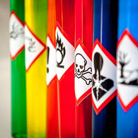 Étiquettes de matières dangereuses sur des contenants colorés dans l'industrie chimique